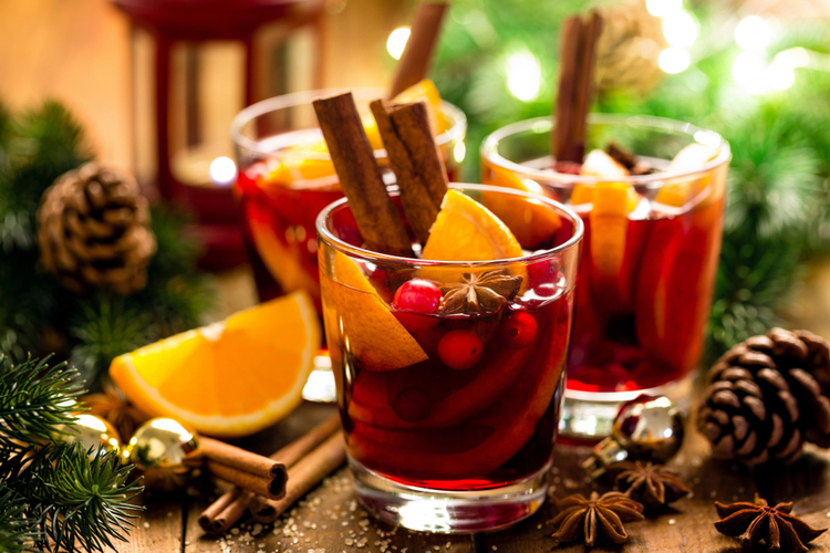 Christmas Mulled Red Wine With Spices and Oranges on a Wooden Rustic Table. Traditional Hot Drink at Christmas