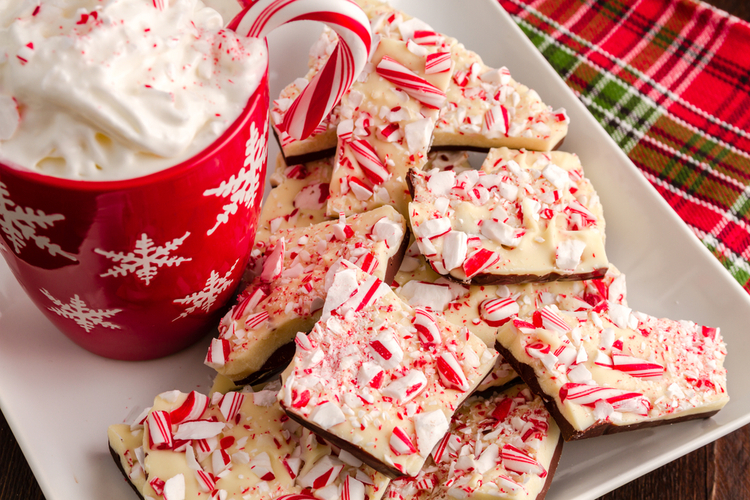 Chocolate Peppermint Bark on White Plate with Red Snowflake Mug Filled With Hot Cocoa and Whipped Cream