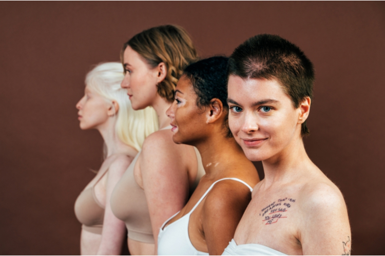 Group of multiethnic women with different kind of skin posing together in studio.