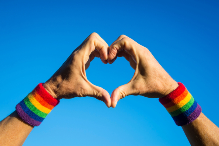 Gay athlete making hand heart with gay pride rainbow colors