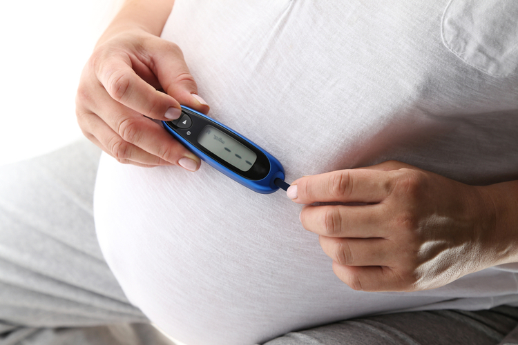 Pregnant woman holding glucose meter. Gestational diabetes.
