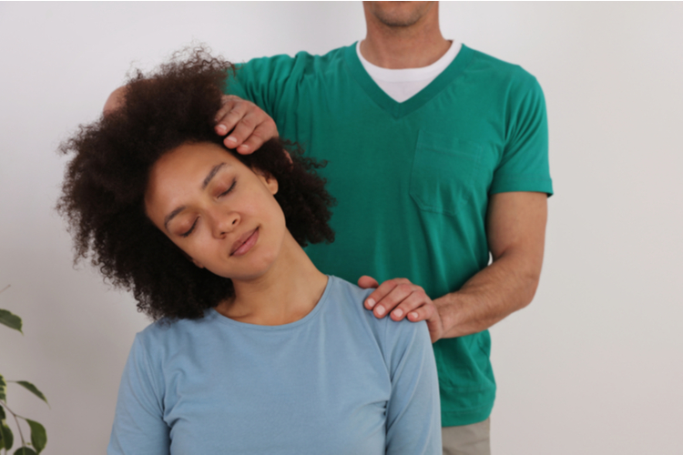 Woman having chiropractic back adjustment in rehabilitation clinic.