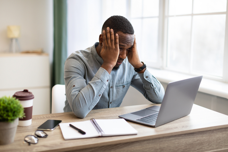 Stressed Businessman At Laptop Touching Head Having Problem At Workplace