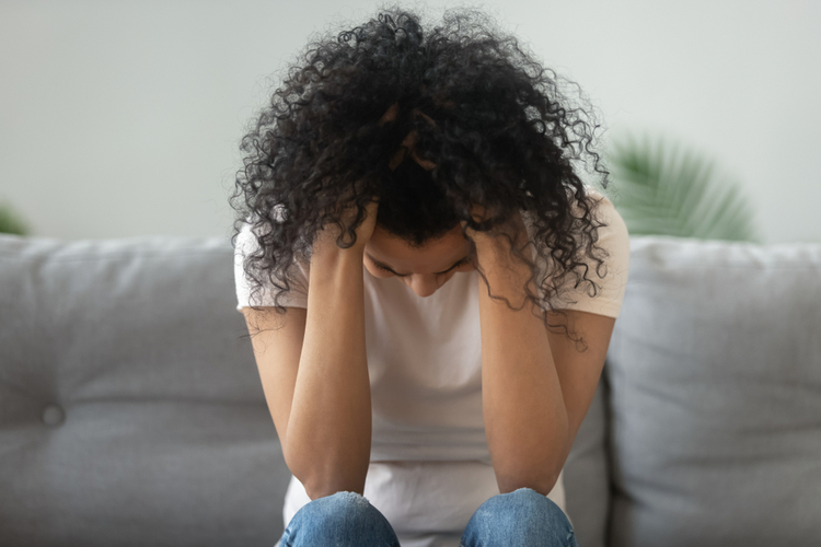 black woman hold head in hands suffer from grief problem