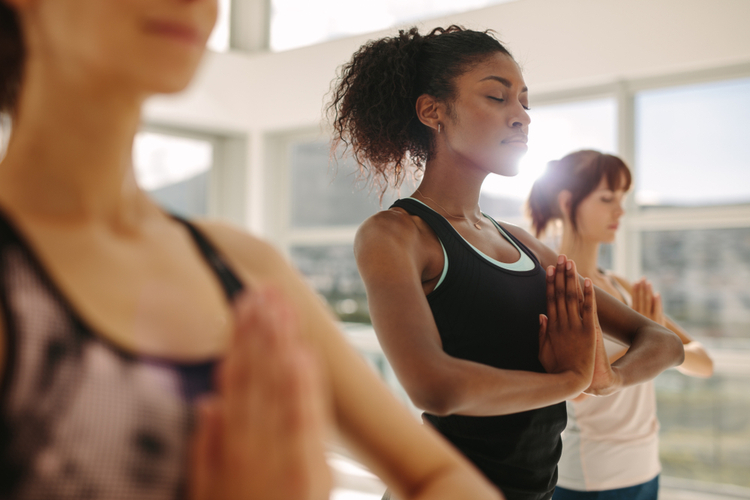 Fit young woman practice yoga with friends.