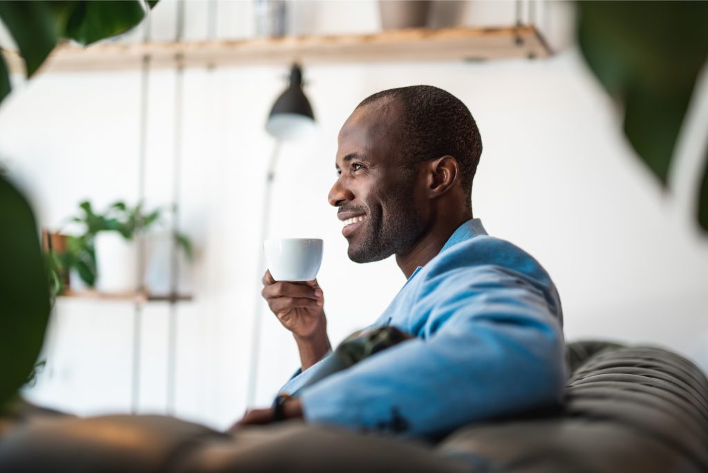 Man drinking mug of delicious beverage while relaxing