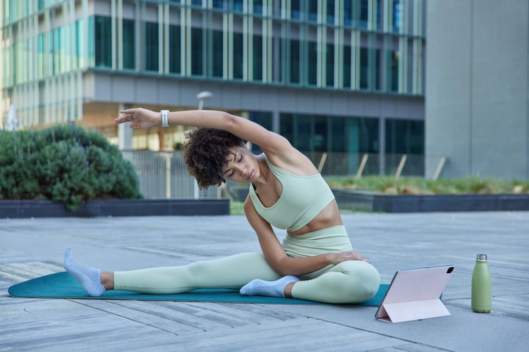 Flexible slim woman in tracksuit exercises yoga poses