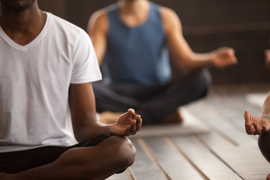Black man in white tshirt meditating