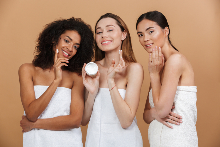 Beauty photo of three smilng multiracial women with different types of skin