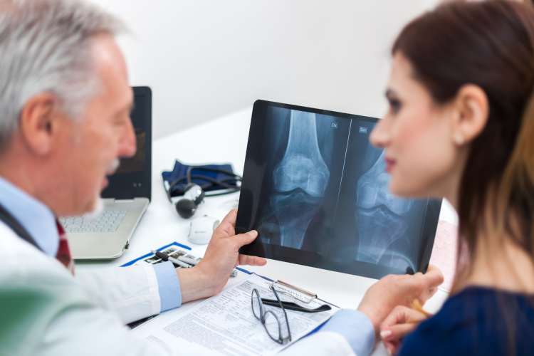 Doctor showing a woman an x-ray of her bones