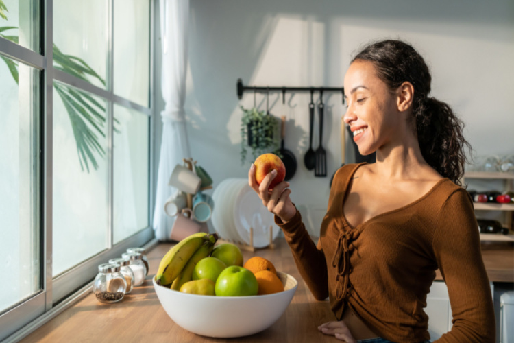 woman eat fruits on table in kitchen at home.