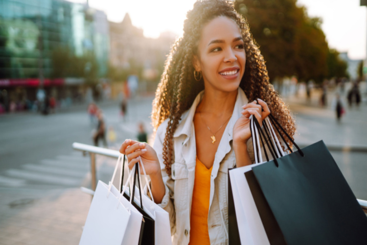 woman with shopping bags walking on street.