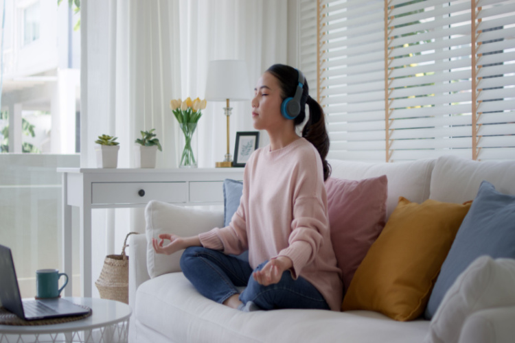 girl close eyes sit on sofa couch at home listening to podcast