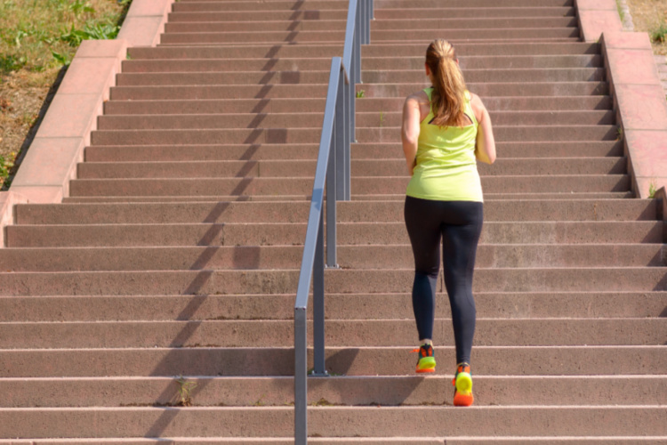 woman running while climbing stairs during intense workout