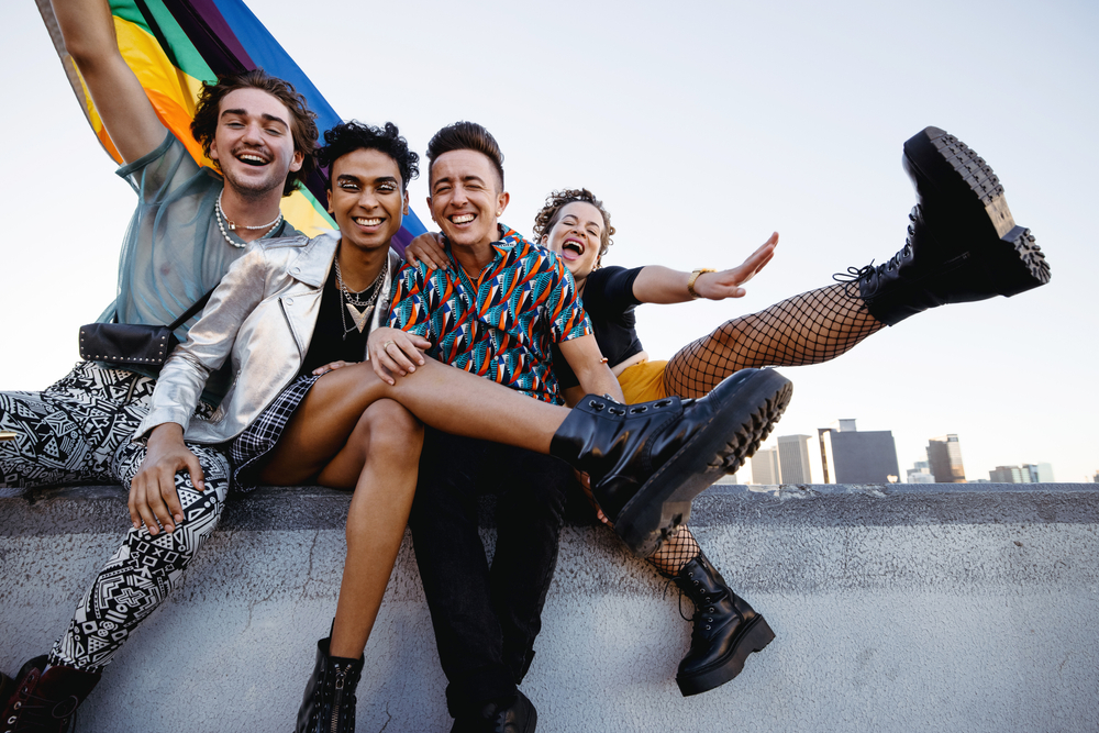 People sitting on a wall with a rainbow flag