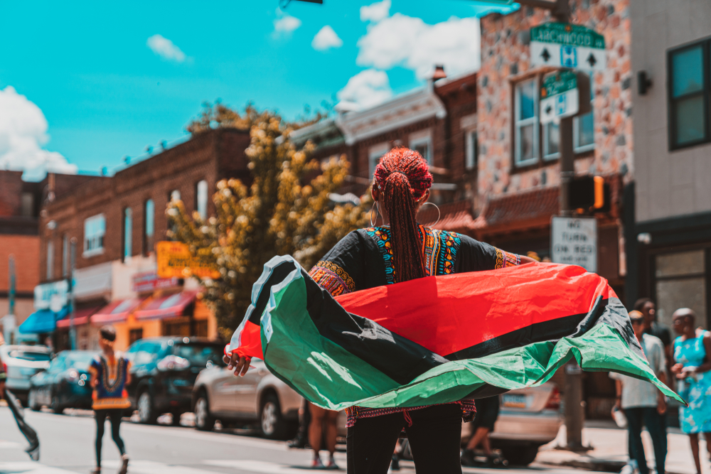 Woman celebrating Juneteenth with flag waving behind her 