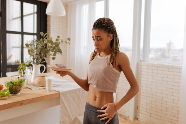  woman leading healthy lifestyle not eating doughnut while having amazing abs