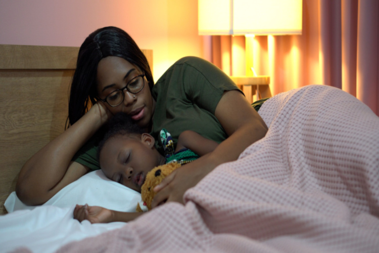 mother singing lullaby for little daughter before going to Sleep