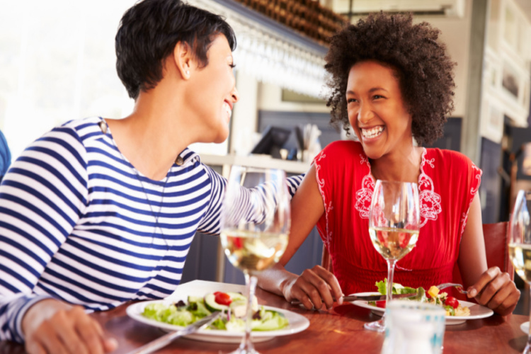Two female friends eating at a restaurant
