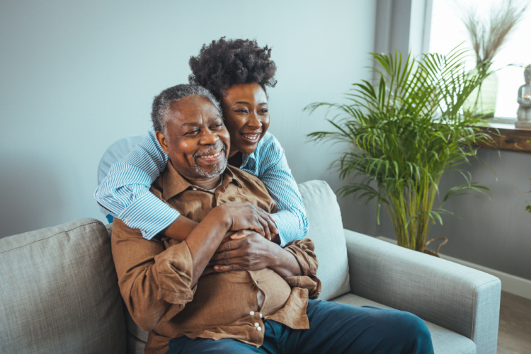 Daughter with her arm around her father both smiling.