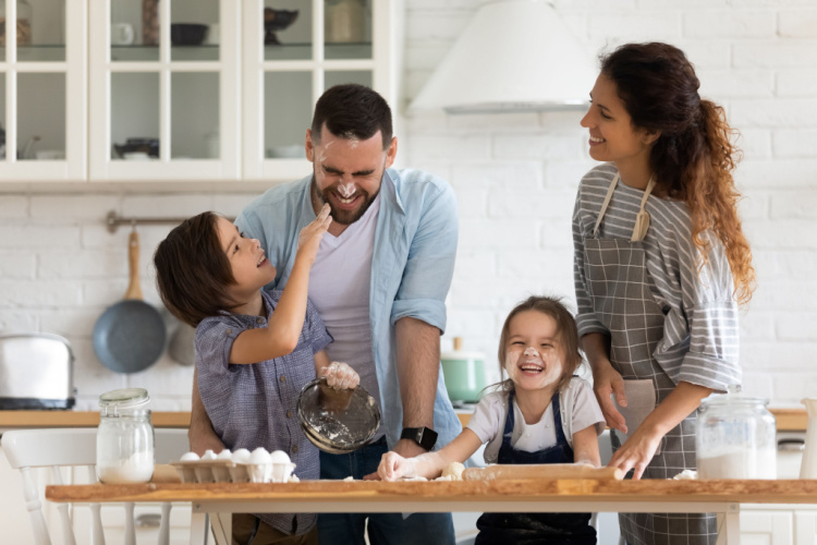 Family with little preschooler kids have fun cooking baking pastry or pie at home together