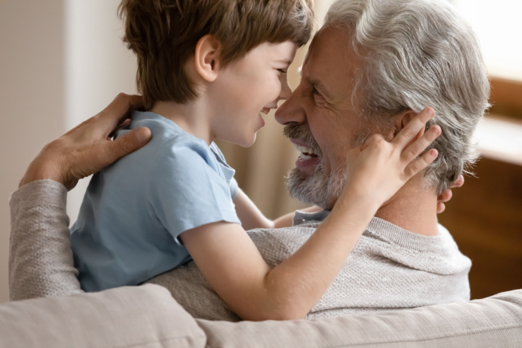child hug cuddle smiling elderly Caucasian grandfather 
