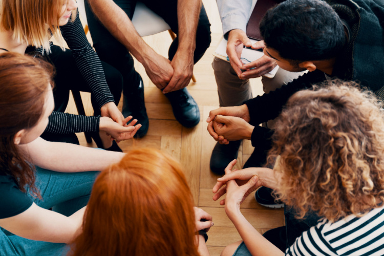 teenagers sitting in a circle during group therapy for bullying victims