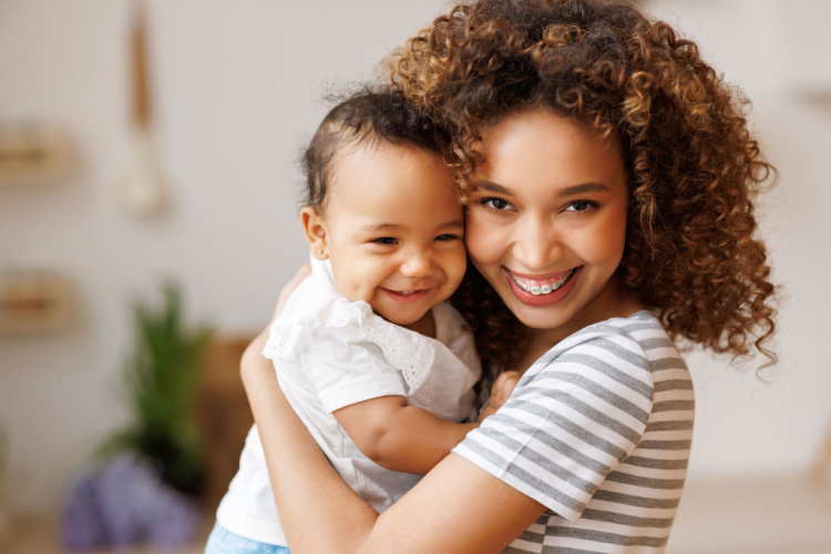 Cheerful african american mother holds a laughing baby daughter in her arms.